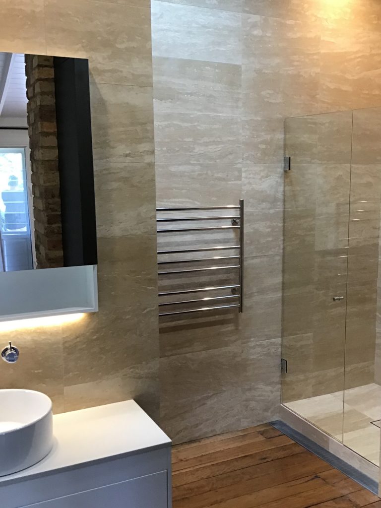 Frameless glass shower screen with polished silver hardware